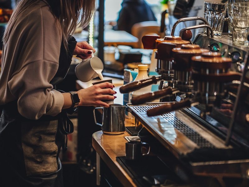 Barista making cappuccion coffee in coffee shop